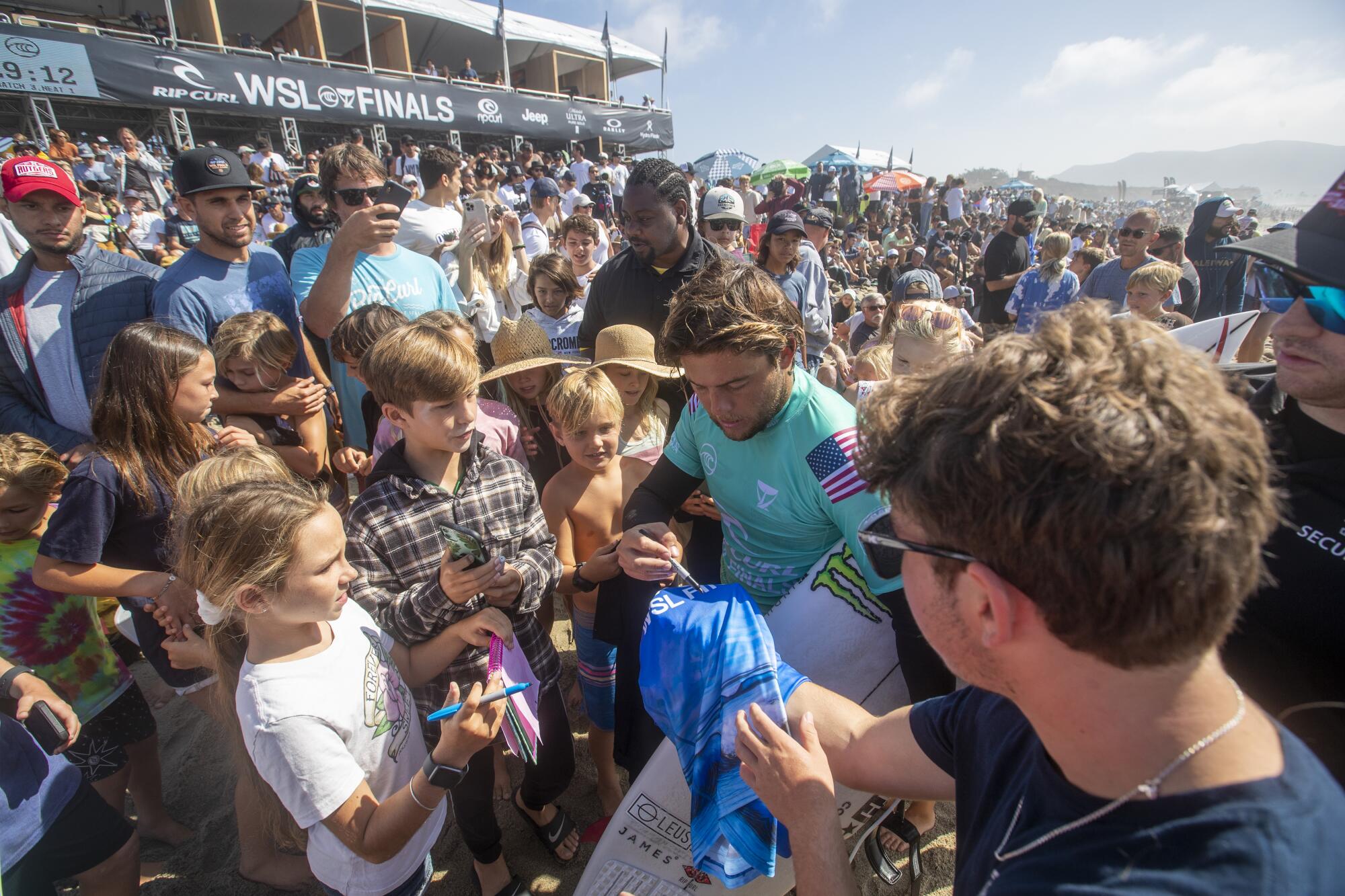 Children and other fans crowd around Conner Coffin to get autographs at the WSL Finals.
