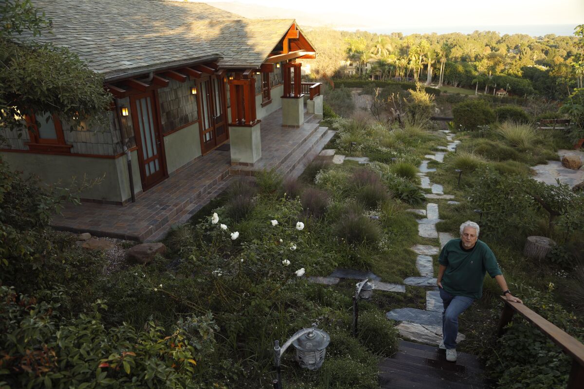 Richard Gibbs stands outside his Woodshed Recording studio surrounded by the moist meadow foliage that survived the Woolsey fire, even as their main house and that of 12 other near neighbors burned to the ground.