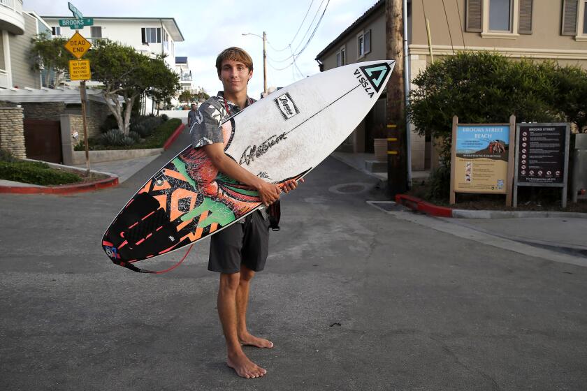 Brayden Belden, of Laguna Beach, stands at Brooks St. after surf session. Belden, previously an age group winner in the Brooks Street Surfing Classic before a brain injury, made his first final at the contest last weekend since his accident.