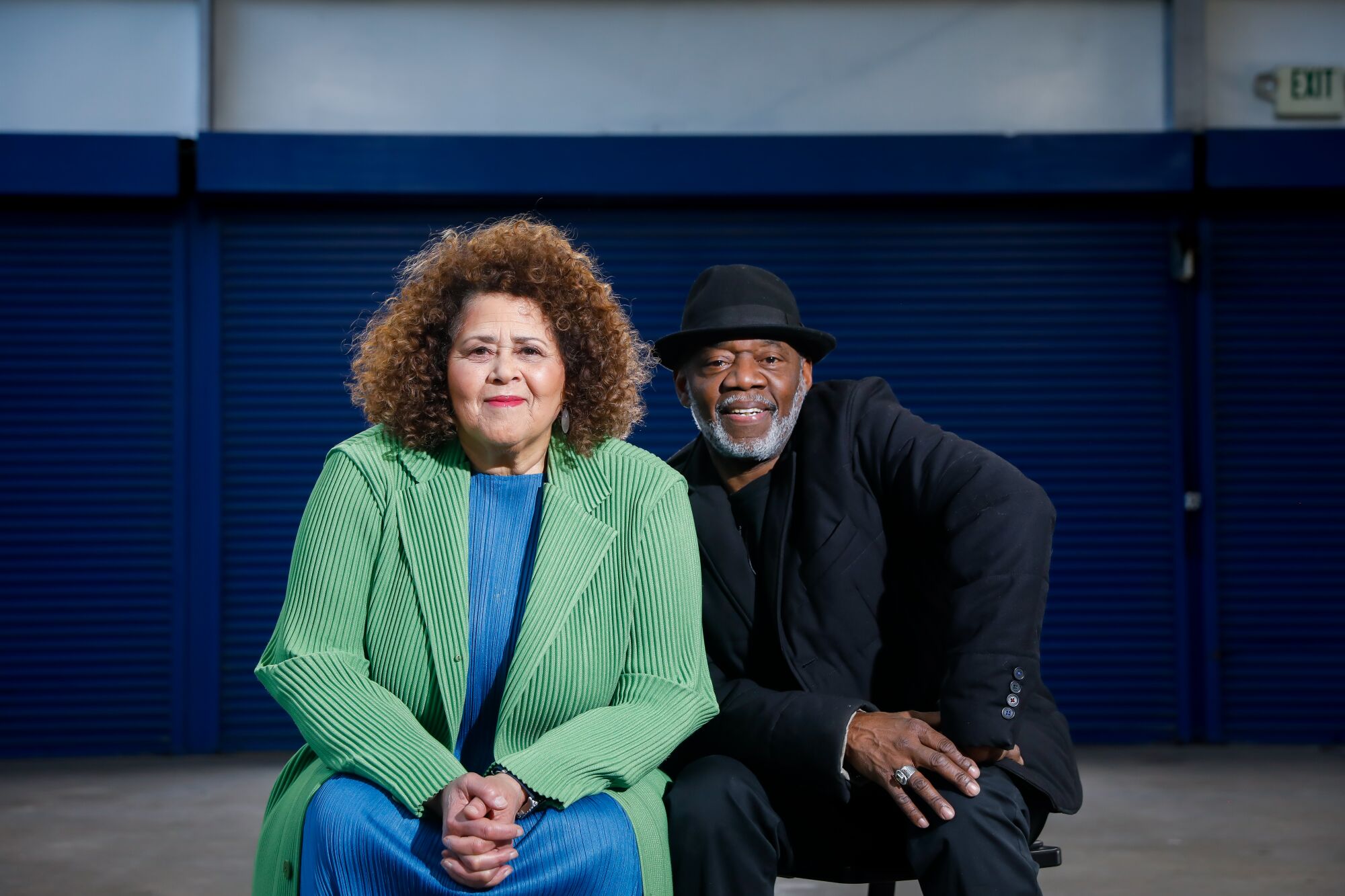 Playwright Anna Deavere Smith and director Gregg Daniel smile for the camera, seated next to each other.
