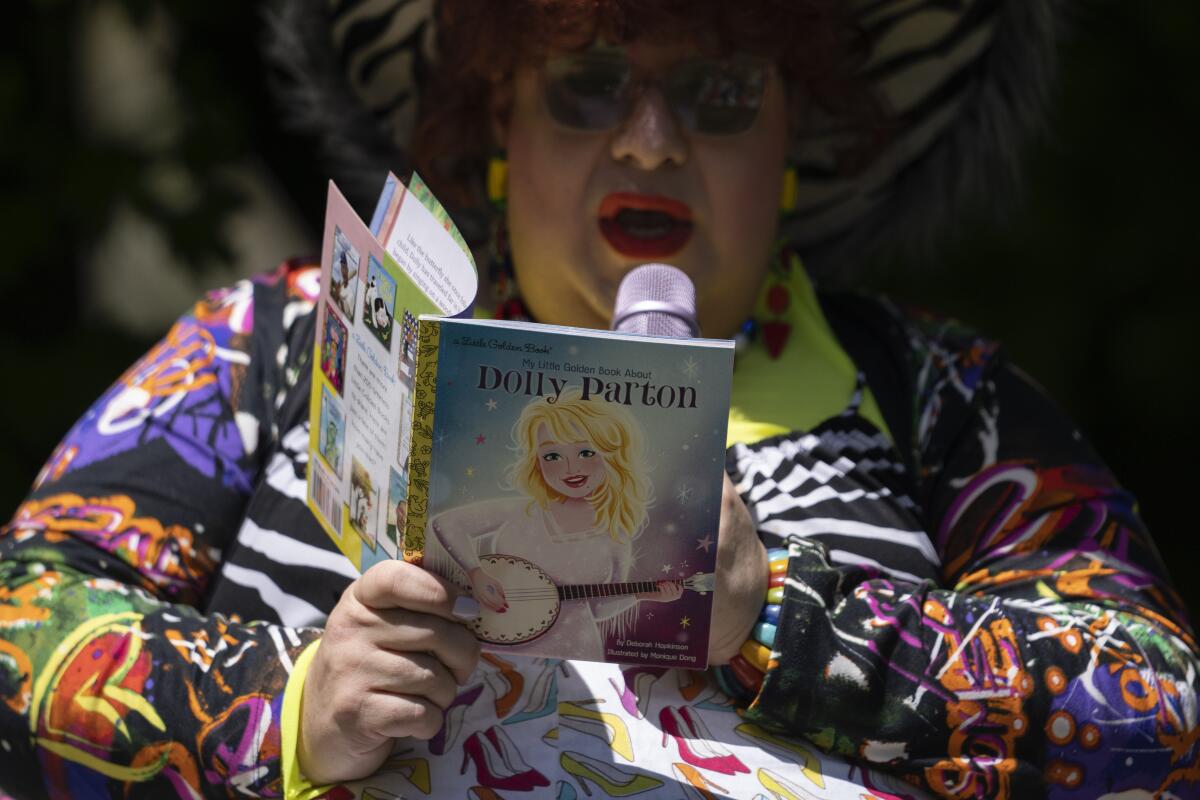 Alexus Daniels reads "My Little Golden Book About Dolly Parton" to children.