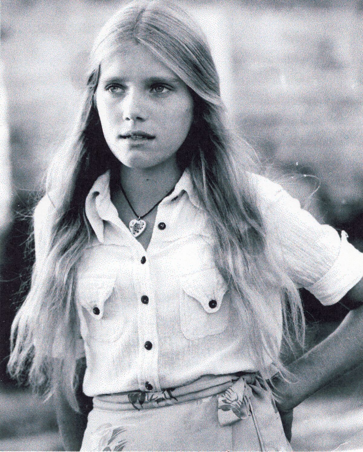 A black-and-white photo of a teen girl with long straight hair.