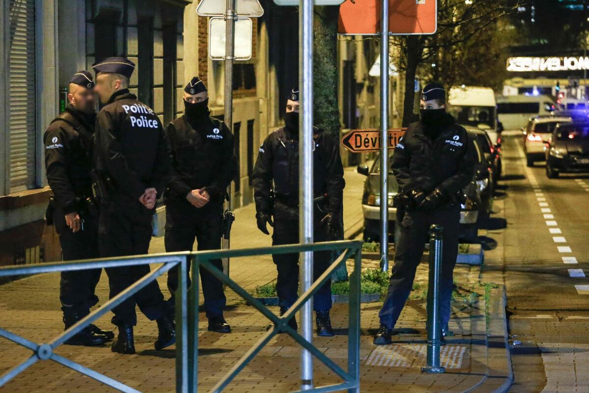 Police officers conduct new searches linked to the Paris terrorist attacks Wednesday in Molenbeek, Brussels.