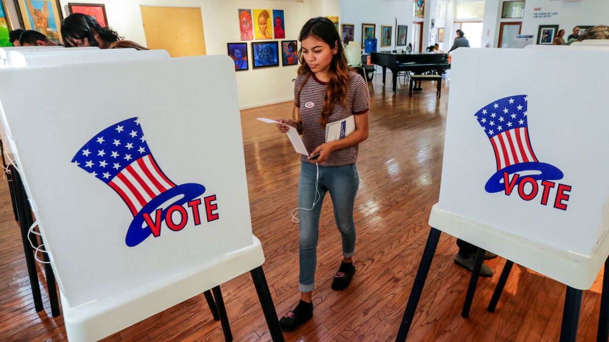 First-time voter Maryjane Medina, 18, approaches a polling booth to cast her vote at the Watts Towers Arts Center. Lawmakers want voters in 2018 to approve a $450-million bond to upgrade voting equipment.
