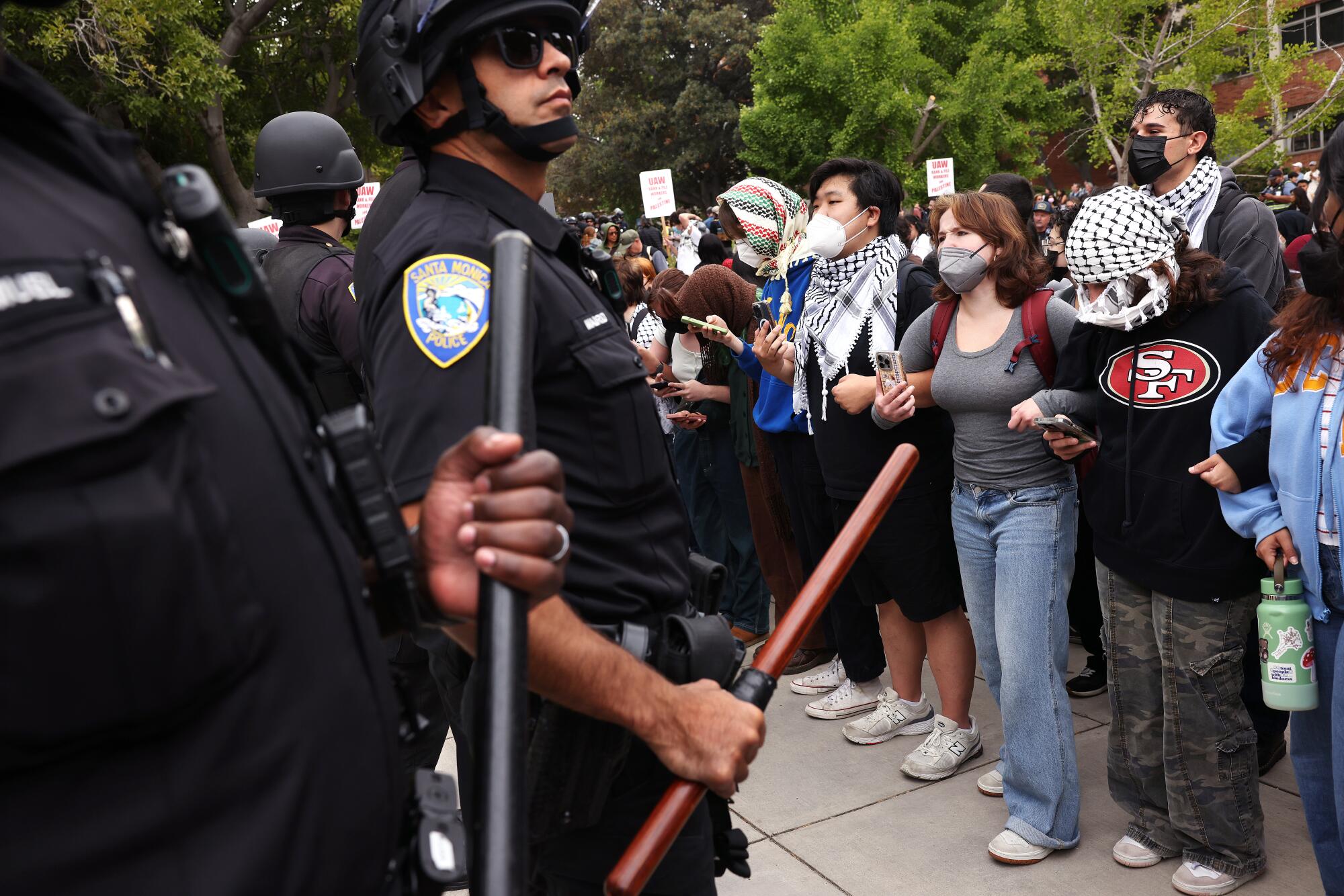 Pro-Palestinian protesters lock arms as police move in to remove a new encampment at UCLA.