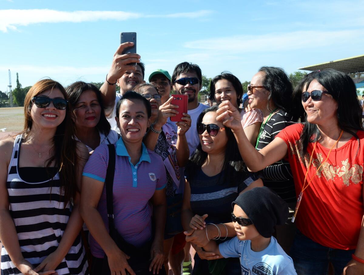 Manny Pacquiao poses for photos with visitors after his training session at a sports complex in General Santos, Philippines, on Friday.