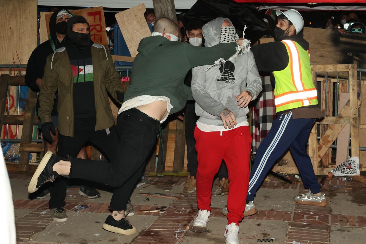   一名蒙面男子殴打一名亲巴勒斯坦抗议者。 