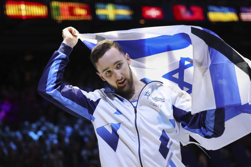 Gold medal winner Israel's Artem Dolgopyat celebrates with the national flag.