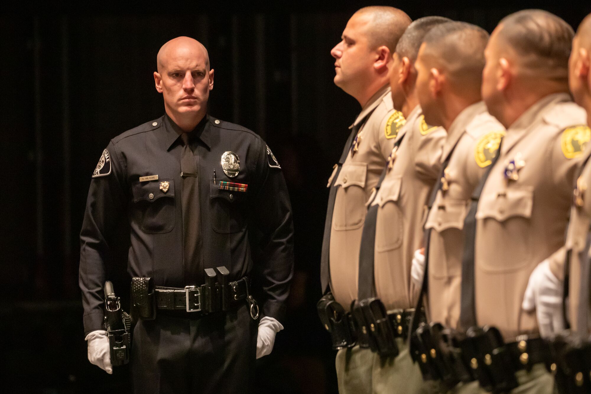 Los Angeles County Sheriff Academy Class 464 graduate Brendan Kilgore, left, checks formation for weapons 