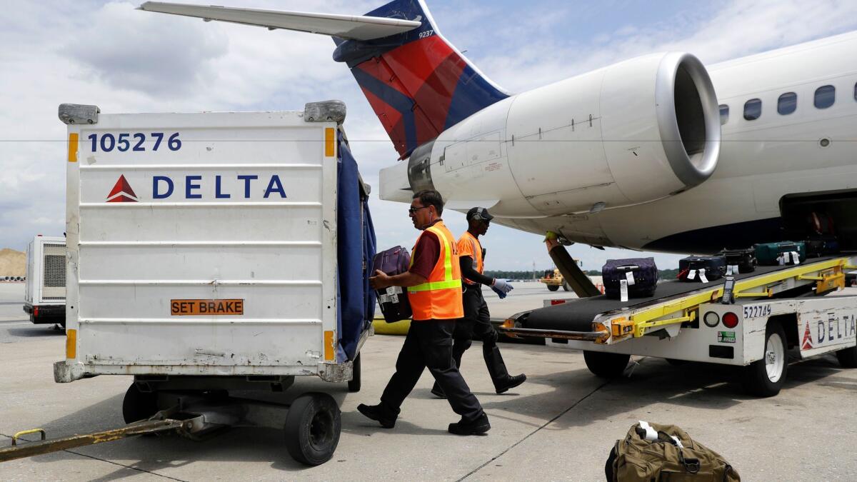 Workers unload baggage from a Delta Air Lines flight at the Baltimore-Washington airport. The Department of Transportation reported that the nation's airlines had the lowest rates of canceled flights and lost luggage in November 2016.