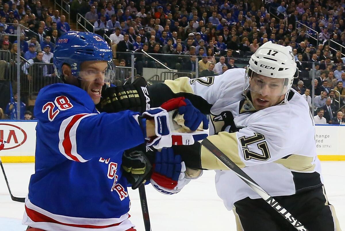 Rangers center Dominic Moore and Penguins forward Blake Comeau battle for positioning along the boards in the first period. The Rangers won 2-1 in Game 1.