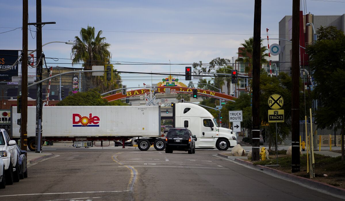 A large semi truck hauls goods along Harbor Drive 
