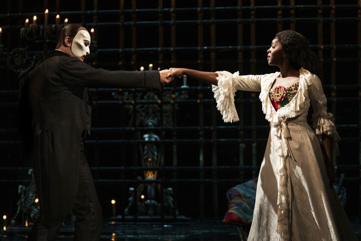 Ben Crawford portrays The Phantom, left, and Emilie Kouatchou portrays Christine in a performance of "The Phantom of the Opera" in New York. Kouatchou is the first Black woman to play the role in the show’s 33-year history. (Matthew Murphy via AP)