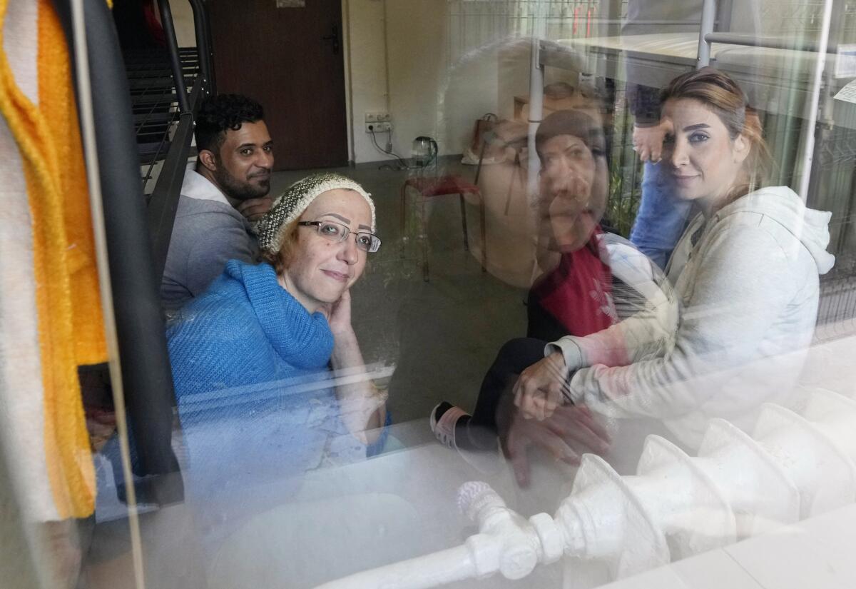 Members of a migrant family looking out a window