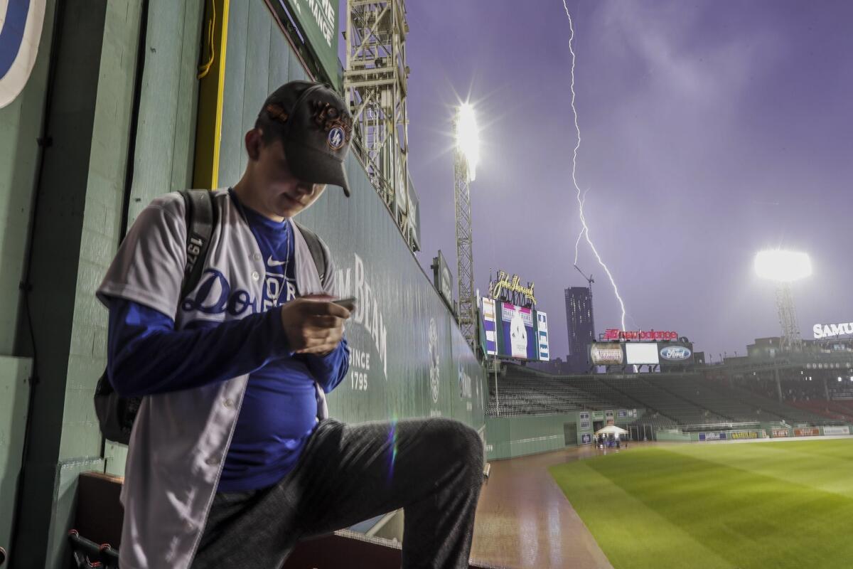 A heavy cell of rain and lightning passes near Fenway Park nearly an hour before game time.