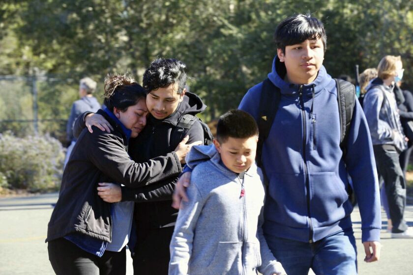 Ana Canul embraces her eldest son Viktor, 17, while her son, Marko, 15, walks with his little brother, Karlos, 10, after the two elder children were released from the lockdown at Montgomery High School in Santa Rosa, Calif., Wednesday, March 1, 2023. Authorities say a 16-year-old student involved in a fight at the Northern California high school was fatally stabbed Wednesday inside a classroom full of students. (Beth Schlanker/The Press Democrat via AP)