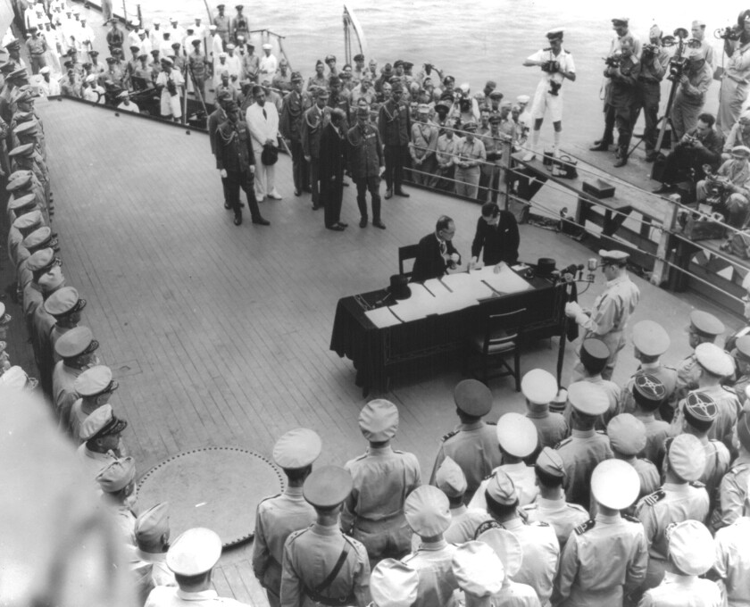 Japanese Foreign Minister Mamoru Shigemitsu, seated, signs the Japanese surrender document on the Missouri in Tokyo Bay on Sept. 2, 1945.