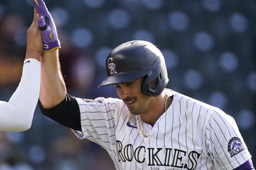 Colorado Rockies' Josh Fuentes is congratulated after hitting a two-run home run off San Diego Padres starting pitcher Blake Snell during the second inning of the second game of a baseball doubleheader Wednesday, May 12, 2021, in Denver. (AP Photo/David Zalubowski)