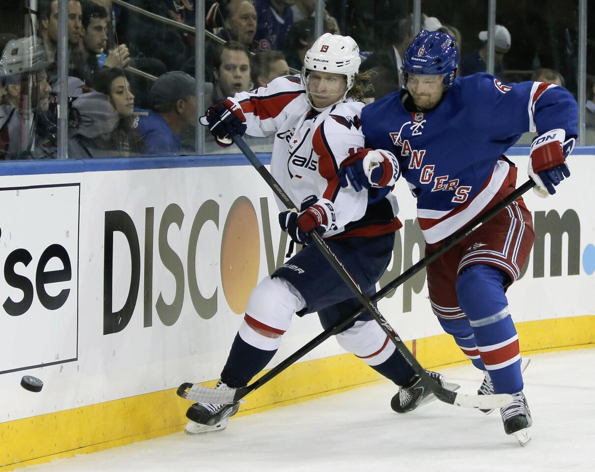 Washington Capitals center Backstrom and New York Rangers defenseman Stralman chase puck in first period of Game 3 of their NHL Stanley Cup playoffs Eastern Conference quarterfinal hockey game in New York