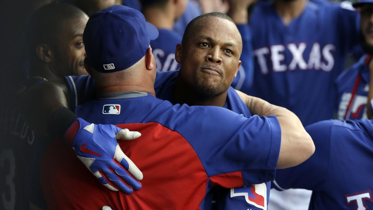 The Texas Rangers' Adrian Beltre, center, receives hugs in the dugout after hitting a three-run home run against the Angels last July.