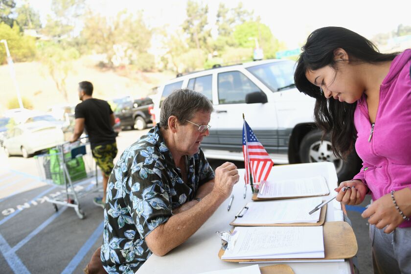 LOS ANGELES-CA-AUGUST 9, 2016: Tim Ecker collects signatures from grocery store patrons including Antonia Lopez, 19, right, in Silverlake on Tuesday, August 9, 2016. (Christina House / For The Times)