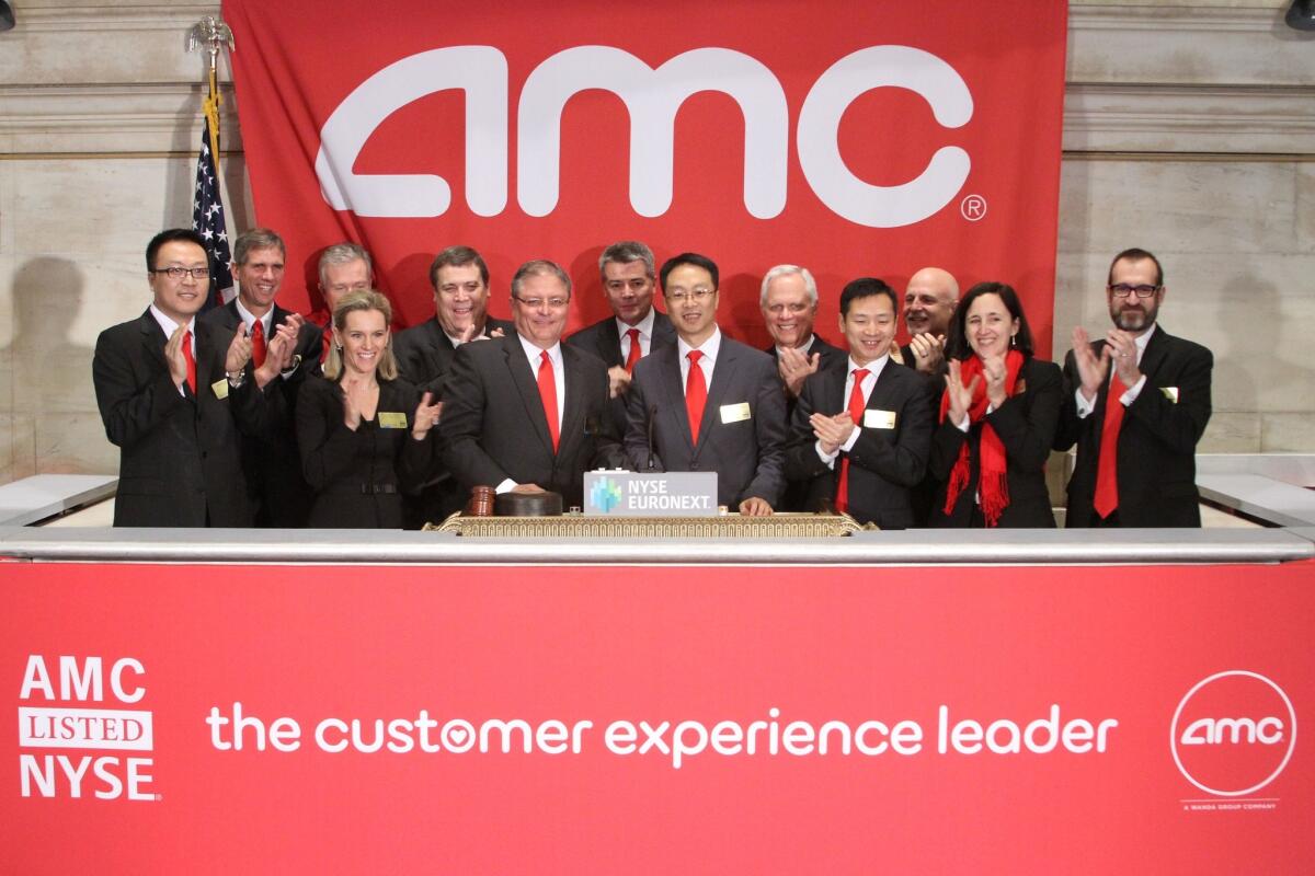 AMC Entertainment CEO Gerry Lopez, sixth from left, rings the opening bell Tuesday at the New York Stock Exchange, where AMC began trading its shares.