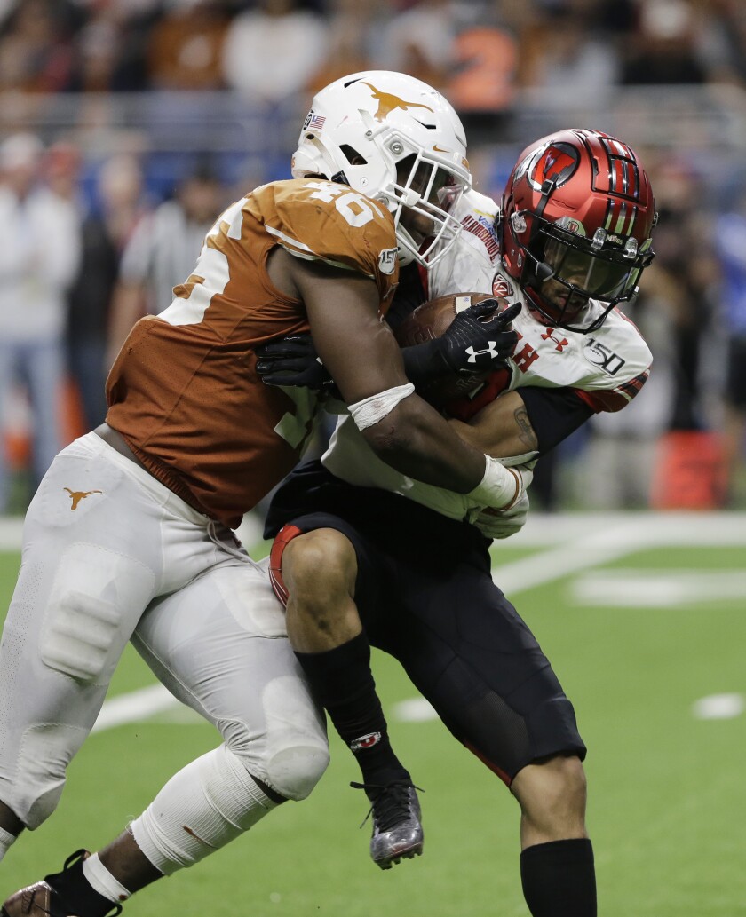 FILE - Texas linebacker Joseph Ossai (46) hits Utah wide receiver Derrick Vickers (8) during the second half of the Alamo Bowl NCAA college football game in San Antonio, Tuesday, Dec. 31, 2019. Ossai should have a big season in a new position. A linebacker in Texas' old 3-4 scheme, Ossai led Texas in tackles, then switched to a rush end position in the Alamo Bowl and delivered three sacks in a dominant win over Utah.(AP Photo/Austin Gay, File)