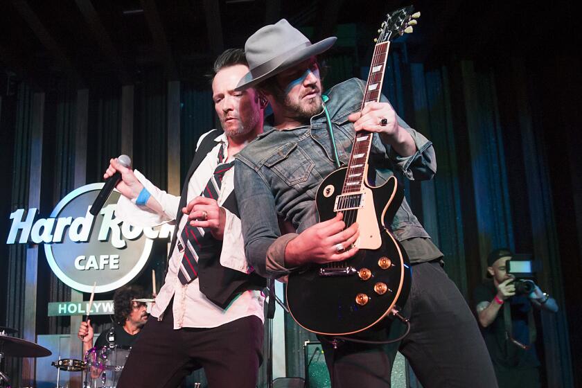 Scott Weiland, left, performs with bandmate Jeremy Brown during an exclusive listening party at Hard Rock Cafe Hollywood in Los Angeles on March 27. Brown died March 30 at his home in Venice. He was 34.
