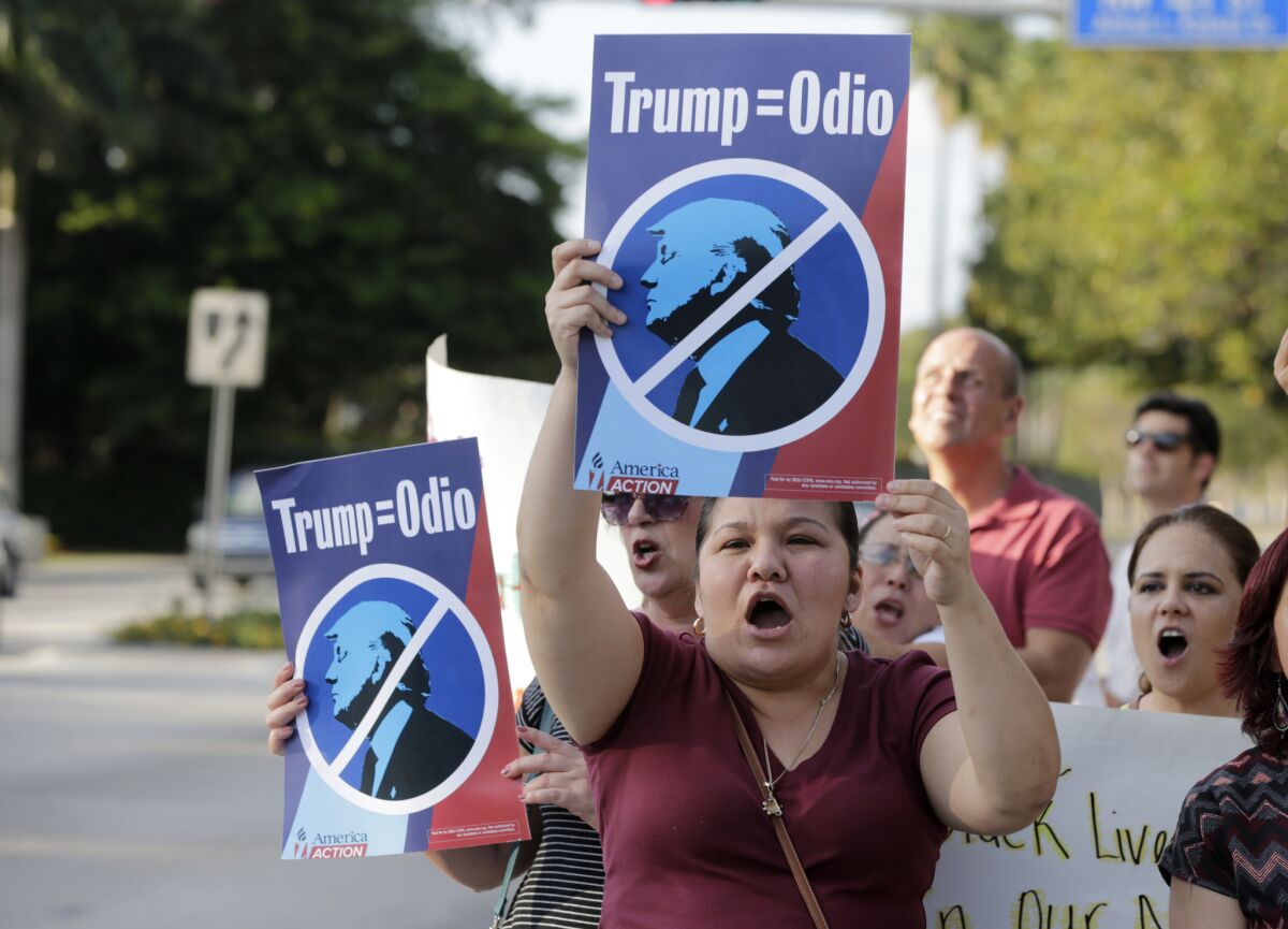 Berta Sandes, an undocumented immigrant from Nicaragua, holds a sign which translates to "Trump Equals Hate" during a protest against Republican presidential candidate Donald Trump on Monday, March 14, 2016, in Doral, Fla.