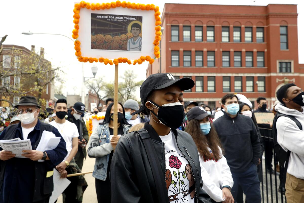 A woman closes her eyes during a rally for Adam Toledo.