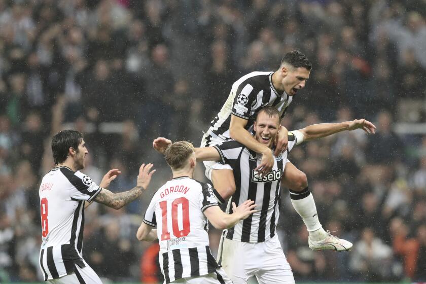 Newcastle's Dan Burn, bottom right, celebrates with teammates after scoring his side's second goalduring the Champions League group F soccer match between Newcastle and Paris Saint Germain at St. James' Park, Wednesday, Oct. 4, 2023, in Newcastle, England. (AP Photo/Scott Heppell)