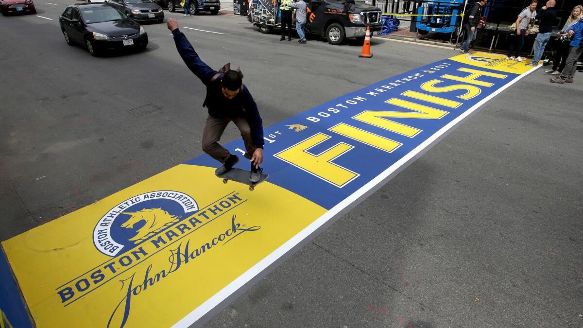 A skateboarder jumps over the Boston Marathon finish line on Boylston Street on Thursday.