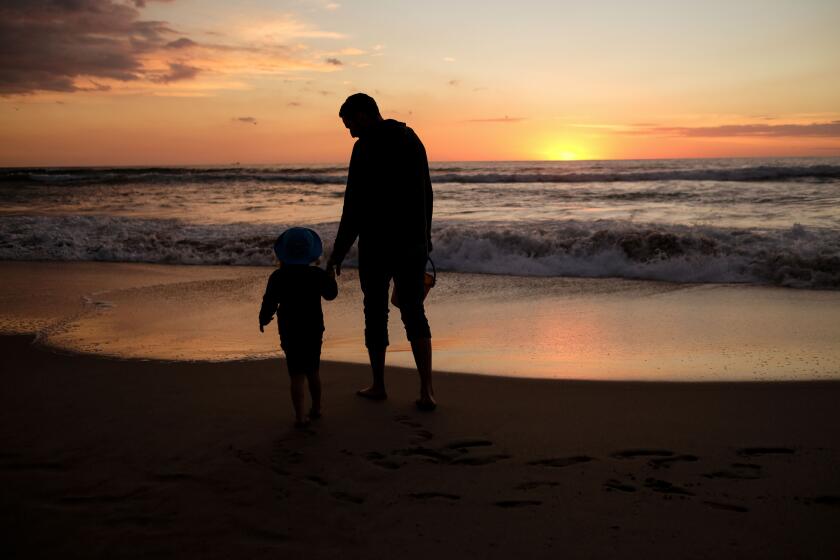 A dad and his daughter enjoy the last sunset of the year in Manhattan Beach, California, on December 31, 2018. (Photo by Chris Delmas / AFP) (Photo credit should read CHRIS DELMAS/AFP via Getty Images)