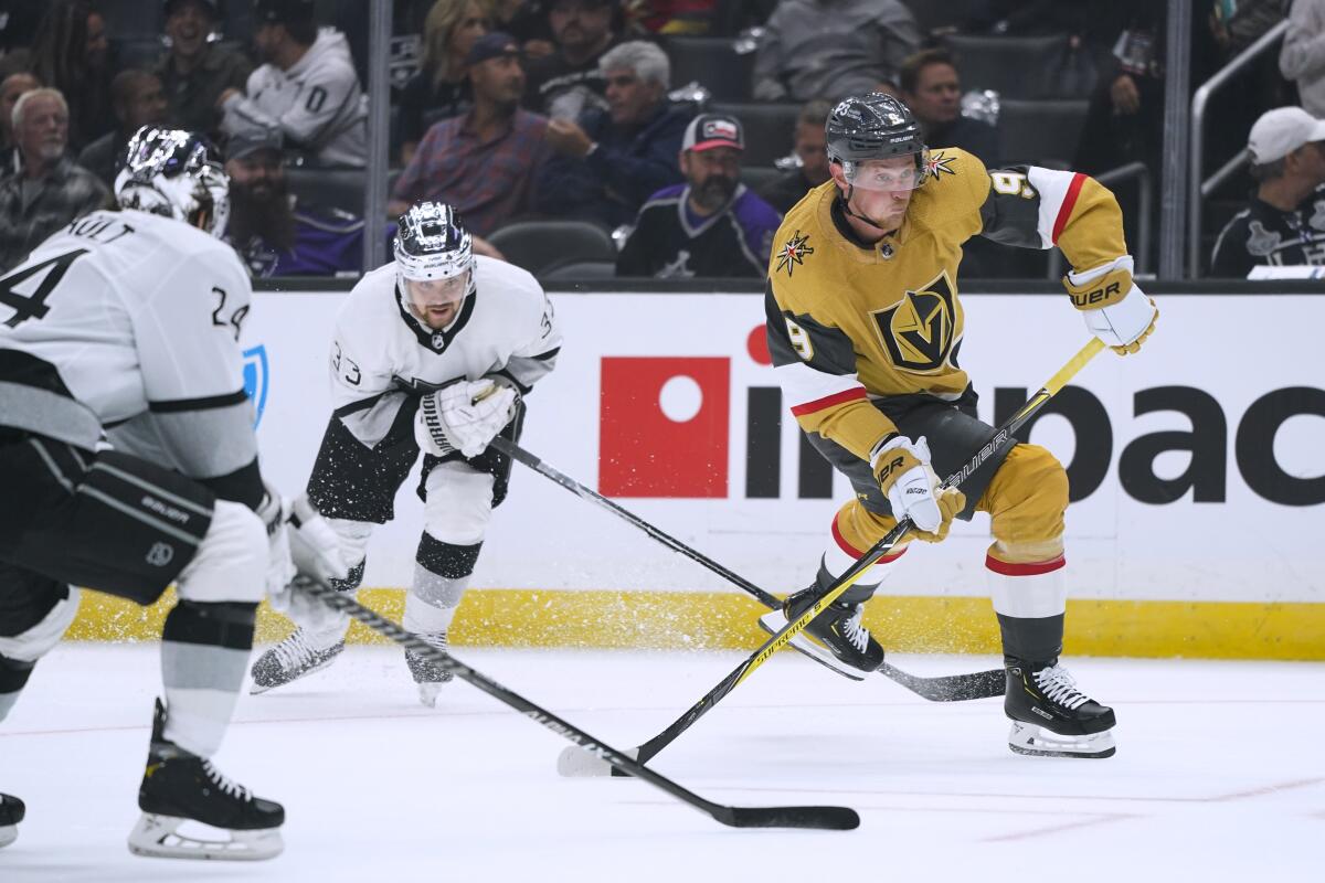 Vegas' Jack Eichel, right, shoots under pressure from Kings' Phillip Danault, foreground, and Viktor Arvidsson.