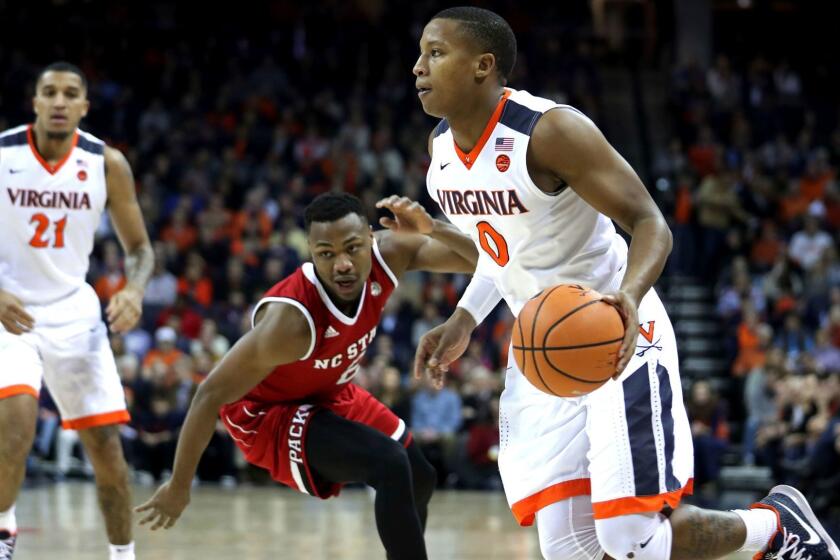 Virginia's Devon Hall (0) drives past North Carolina State's Torin Dorn (2) in the first half of an NCAA college basketball game Sunday, Jan. 14, 2018, in Charlottesville, Va. (Zack Wajsgras/The Daily Progress via AP)