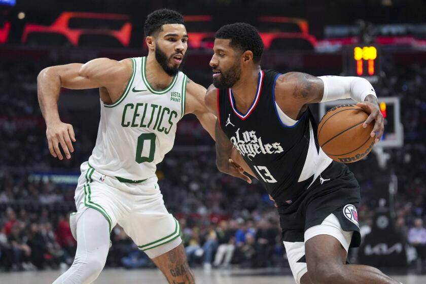 Los Angeles Clippers forward Paul George (13) drives against Boston Celtics forward Jayson Tatum (0) during the first half of an NBA basketball game in Los Angeles, Saturday, Dec. 23, 2023. (AP Photo/Eric Thayer)