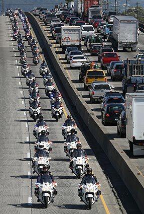 Motorcycle officers follow the funeral procession for four Oakland police officers after the service.