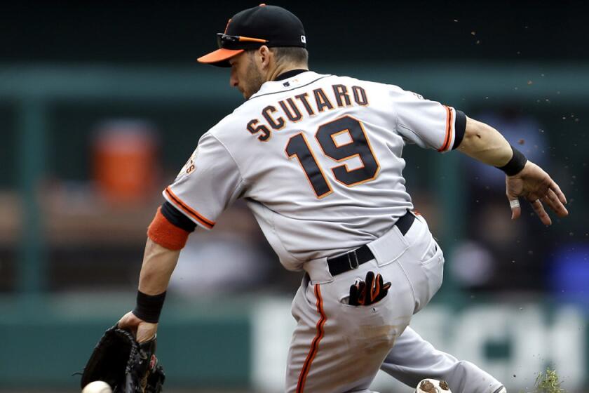 San Francisco Giants second baseman Marco Scutaro stops a grounder hit by St. Louis Cardinals' Matt Adams during a game on June 2, 2013. The Giants have re-signed second baseman Scutaro to a major league contract that pays him $6 million this year even though he may never play baseball again following back surgery.