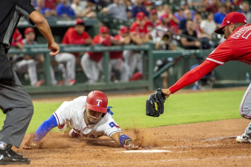 Texas Rangers' Robinson Chirinos scores ahead of the tag of Los Angeles Angels relief pitcher Osmer Morales (73) on a wild pitch by Morales during the eighth inning of a baseball game, Thursday, Aug. 16, 2018, in Arlington, Texas. Texas won 8-6. (AP Photo/Jeffrey McWhorter)