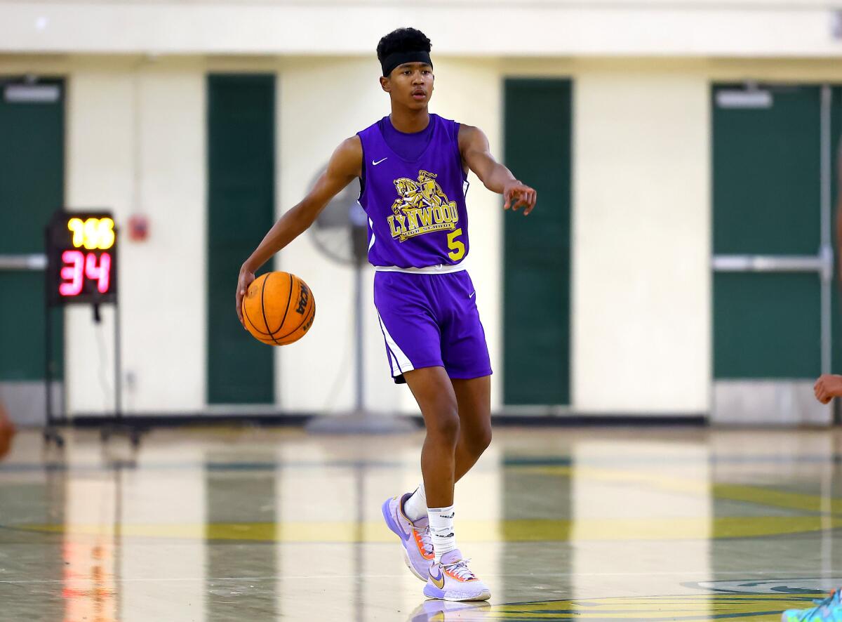 Freshman Jason Crowe Jr. of Lynwood High brings the ball up court while directing teammates.