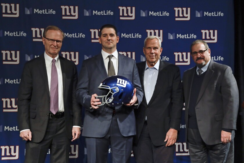 FILE - New York Giants new NFL football head coach Joe Judge, second from left, poses for photographs with New York Giants chairman and executive vice president Steve Tisch, second from right, New York Giants CEO John Mara, left, and New York Giants general manager Dave Gettleman, right, after a news conference Thursday, Jan. 9, 2020, in East Rutherford, N.J. Seeing the Giants struggles in a four-win season that led to the retirement of general manager Dave Gettleman and the firing of coach Joe Judge was the low point in co-owner John Mara’s more than 30-year association with the franchise. Speaking less than 24 hours after firing his third coach since December 2017, Mara said Wednesday, Jan. 12, 2022, the Giants need to build from the ground up. (AP Photo/Frank Franklin II, File)