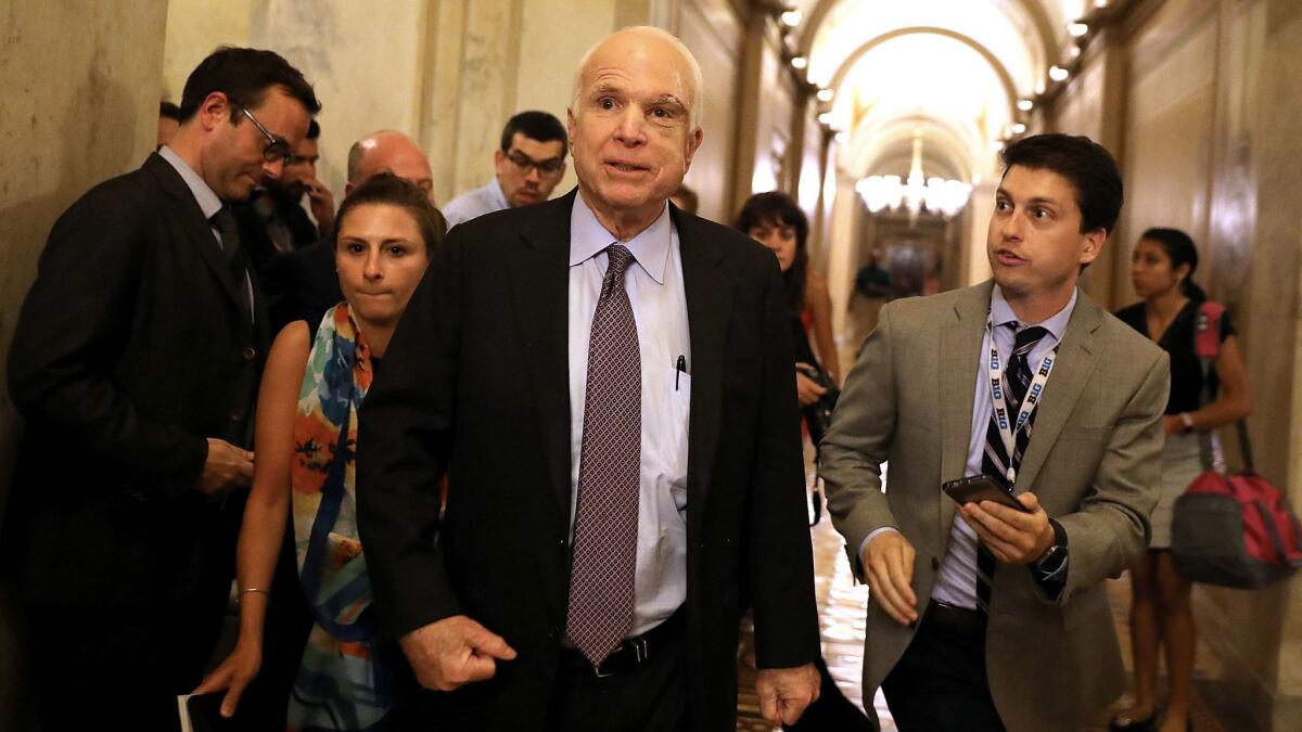 Sen. John McCain leaves the the Senate chamber after voting against the "skinny repeal" plan.