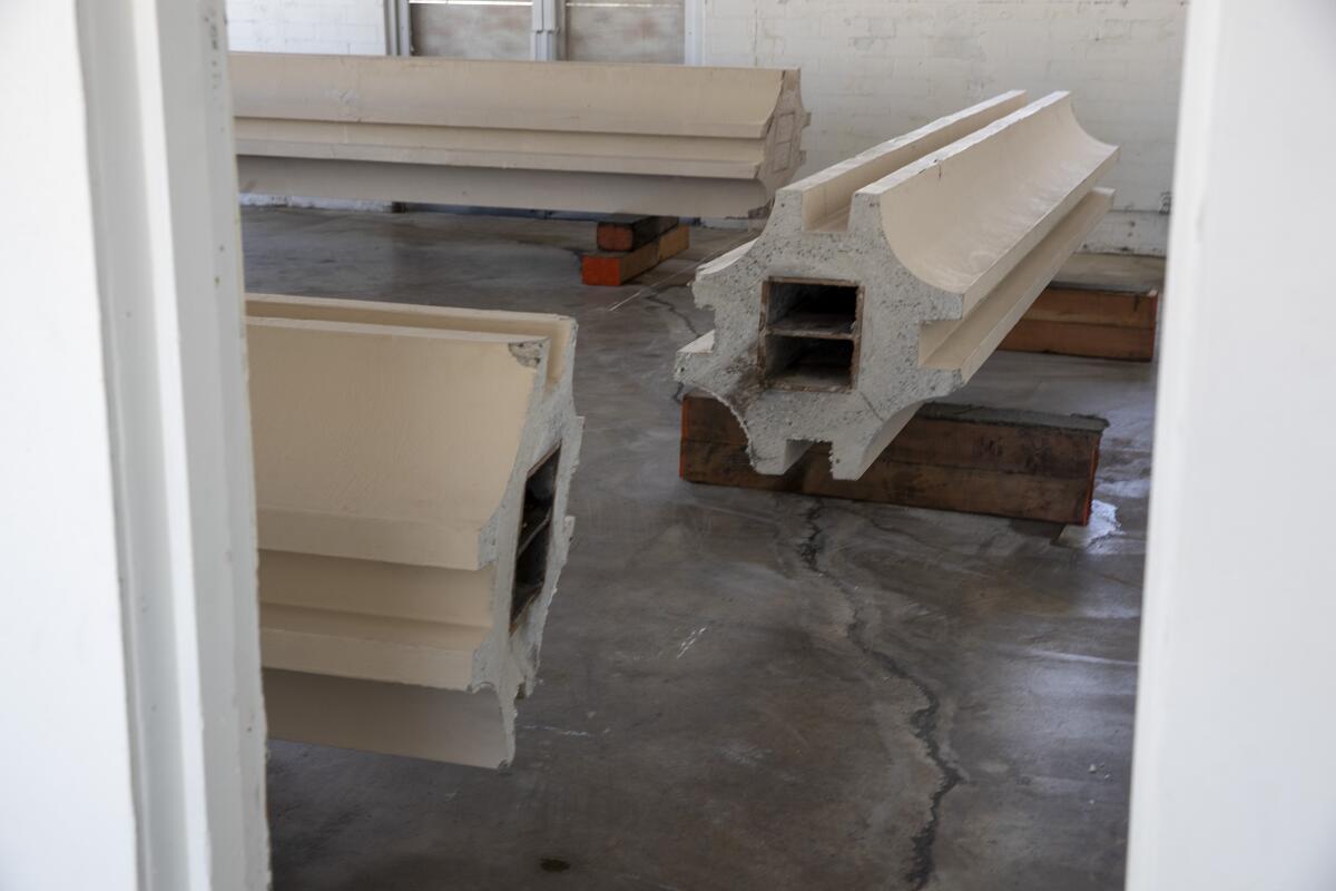 Fragments of columns from LACMA's Ahmanson building are shown resting on their side in a storefront gallery space.