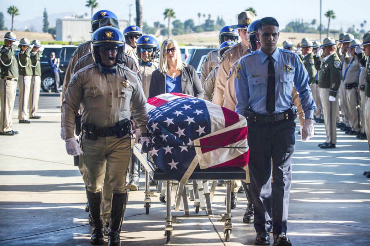 The flag-draped casket of fallen CHP Officer Andre Moye Jr. arrives at Harvest Christian Fellowship Church in Riverside on Tuesday.