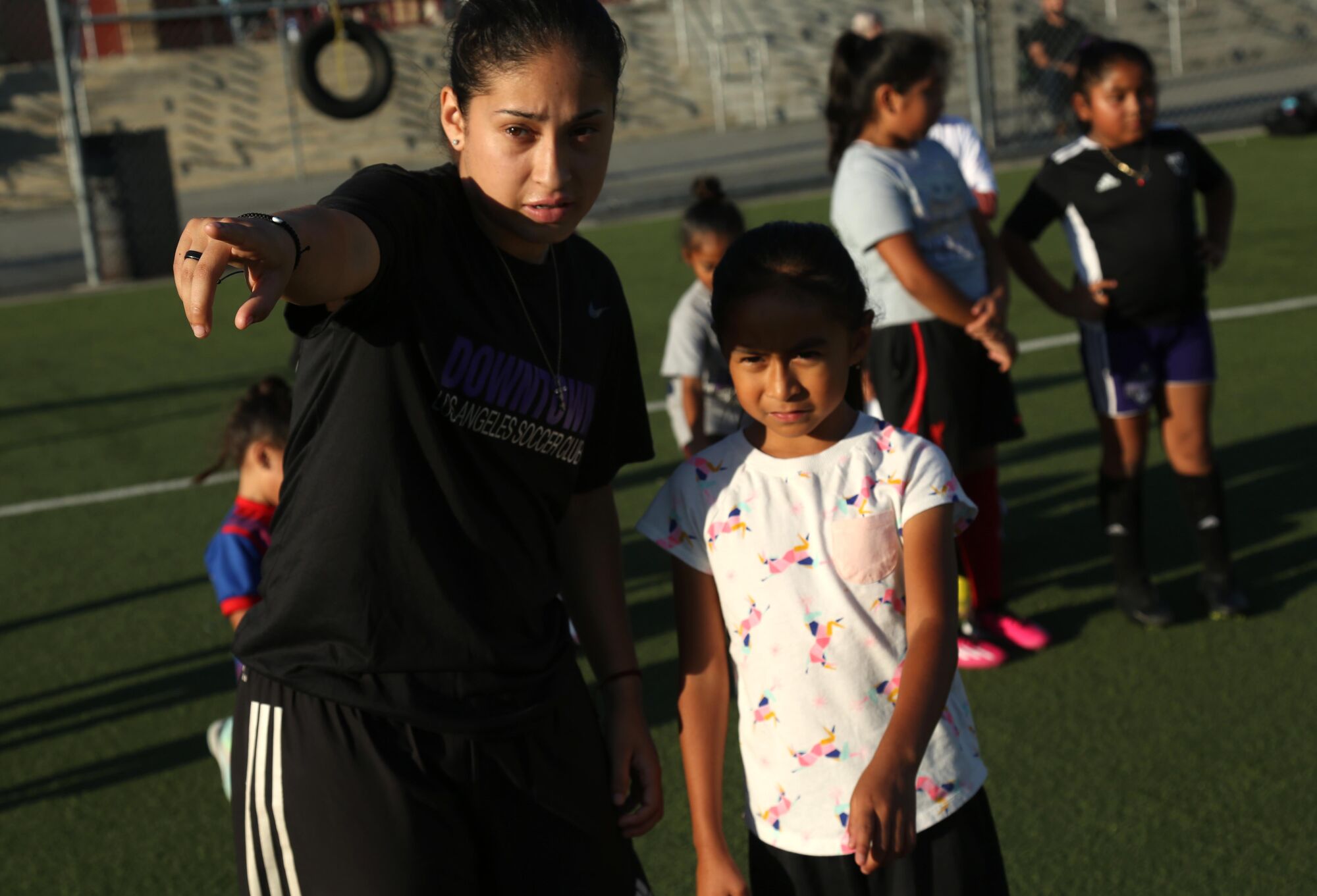 Nayelli Barahona, Downtown LA Futbol Kulübü antrenmanı sırasında genç bir kızı işaret ediyor ve ona yön veriyor.