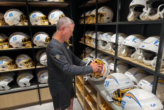 Chris Smith, director of equipment operations for the Chargers, inspects helmets.