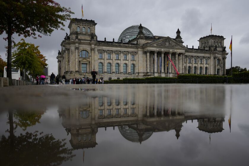 The Reichstag Building which are the German parliament Bundestag building reflected in a puddle in Berlin, Tuesday, Sept. 28, 2021. Sunday's national election making Germany's lower house of parliament, or Bundestag, more diverse and inclusive than ever before. For the first time there are also two transgender women, at least three people of African descent and, after years of stagnation, the number of female lawmakers has gone up again as well. (AP Photo/Markus Schreiber)