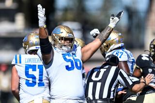 Offensive lineman Atonio Mafi #56 of the UCLA Bruins lifts his arms as a field goal attempt is good 