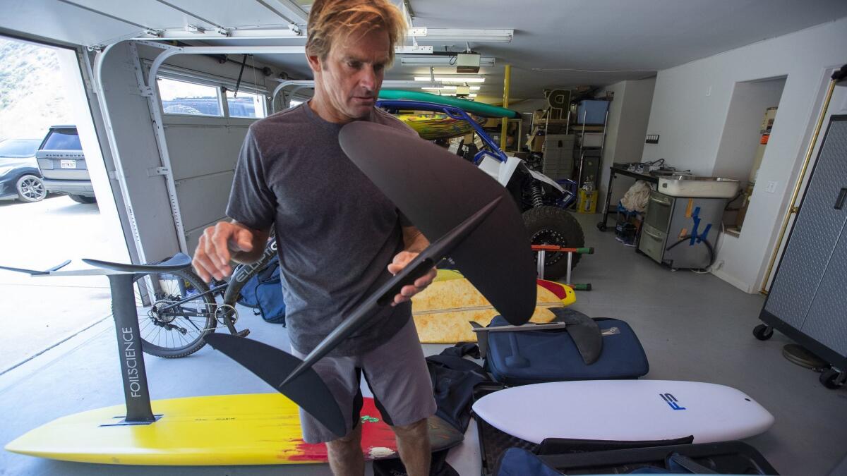 Hamilton inspects his foilboards as he prepares for a surfing trip to Peru. He no longer surfs on traditional surfboards.