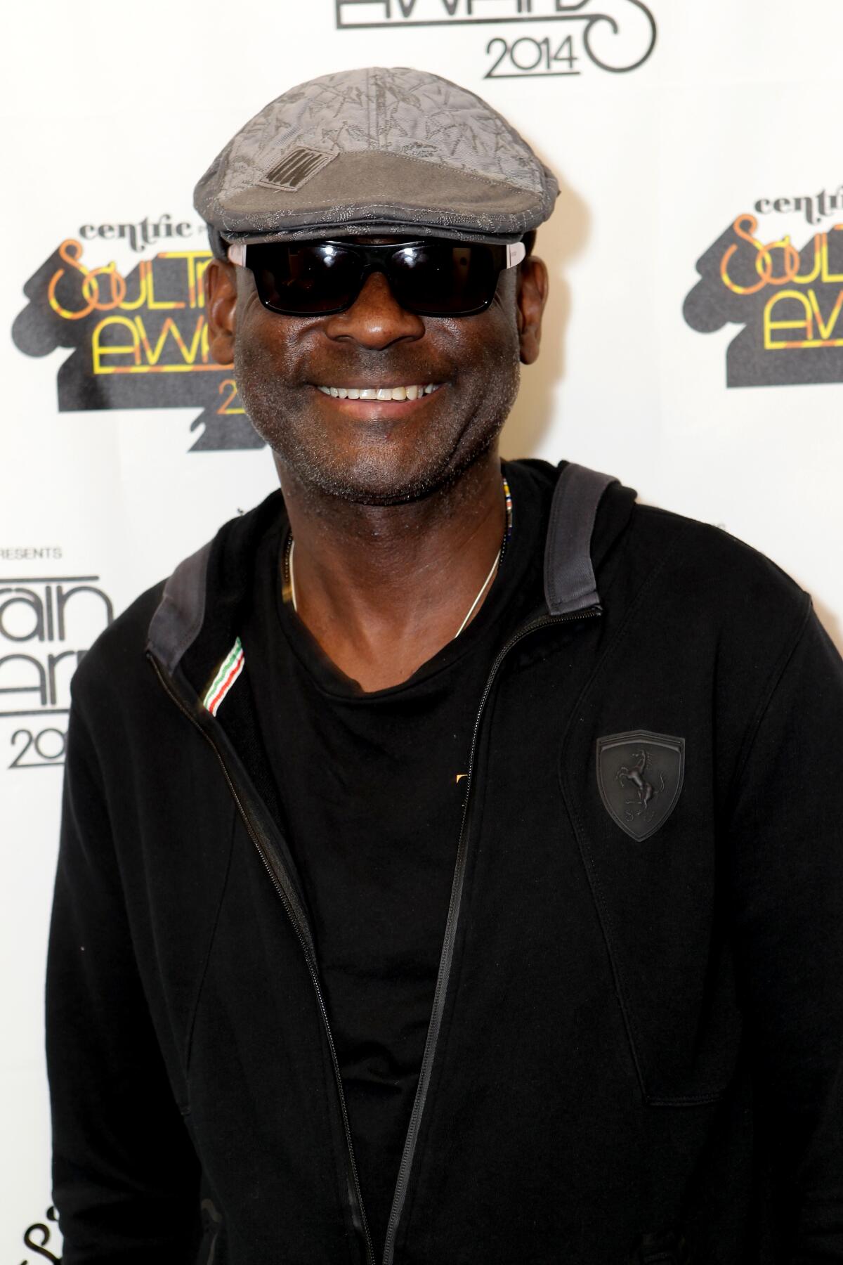 An R&B musician in sunglasses and a cap